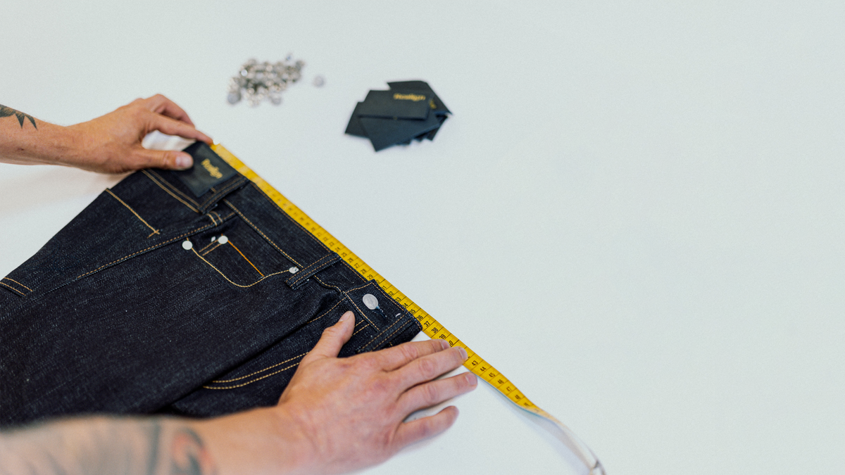 Measuring a pair of Realign jeans laid flat